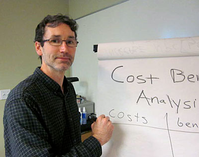 Photo of Rick Goggins demonstratng cost benefit analysis